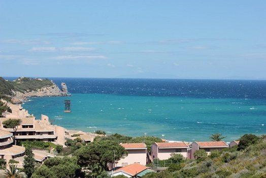 Abbildung 4: Blick auf die Bucht von Campese beim Aufstieg nach Castello – mit den 3 Fördertürmen, wobei nur noch der dritte Turm voll erhalten ist. Im Hintergrund in blasser Silhouette, die Insel Elba.